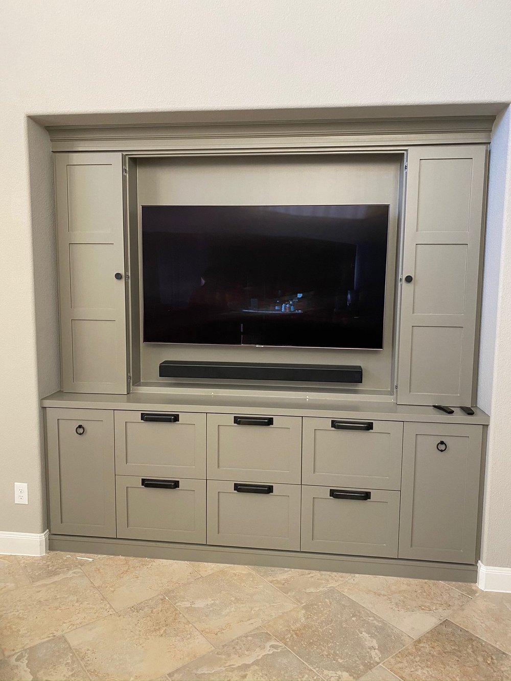A television integrated into built-in cabinetry with organized equipment connections.